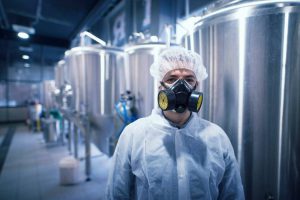 operario en una fábrica con máscara de gas